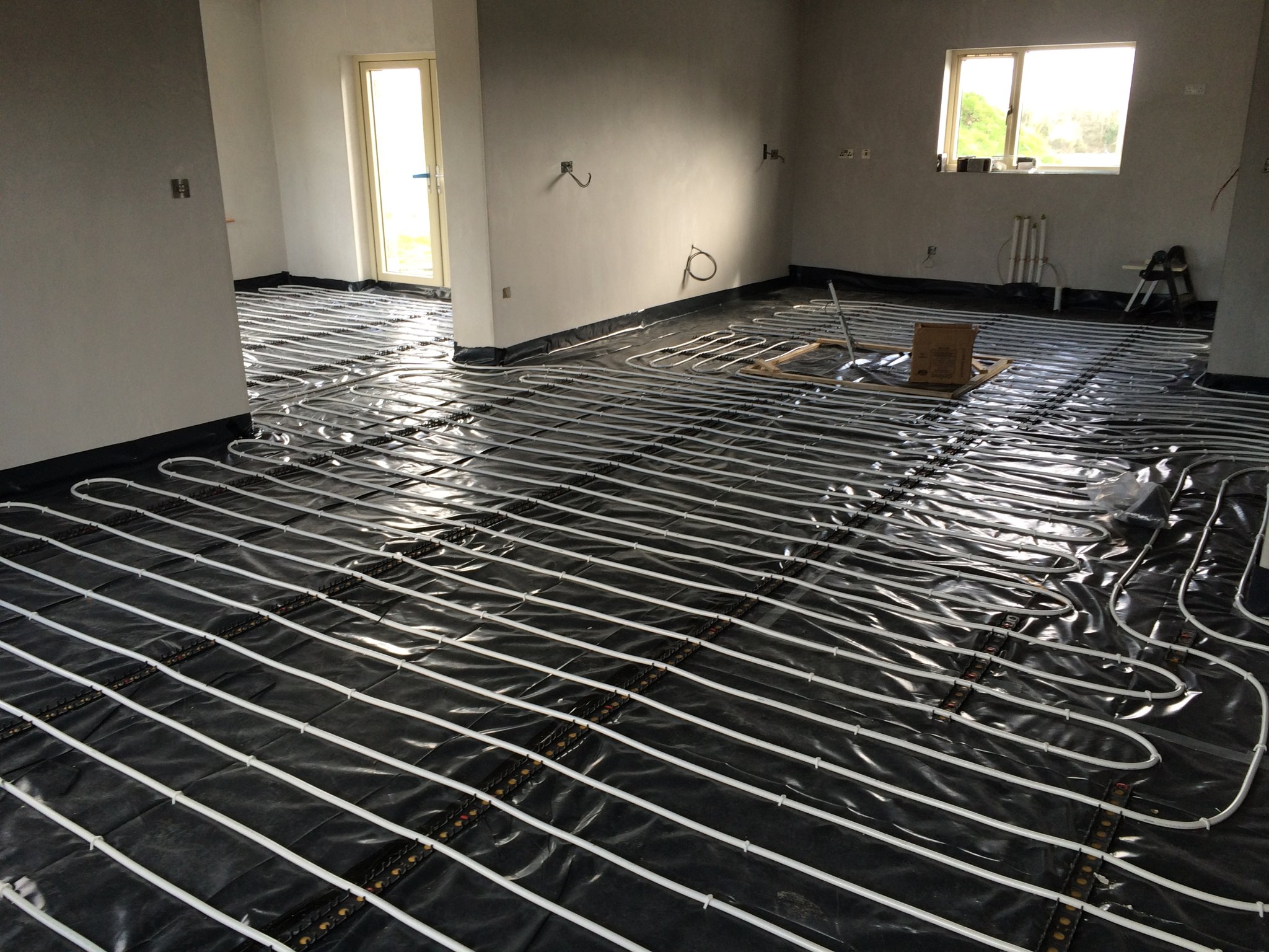 Underfloor heating pipes laid across a large room