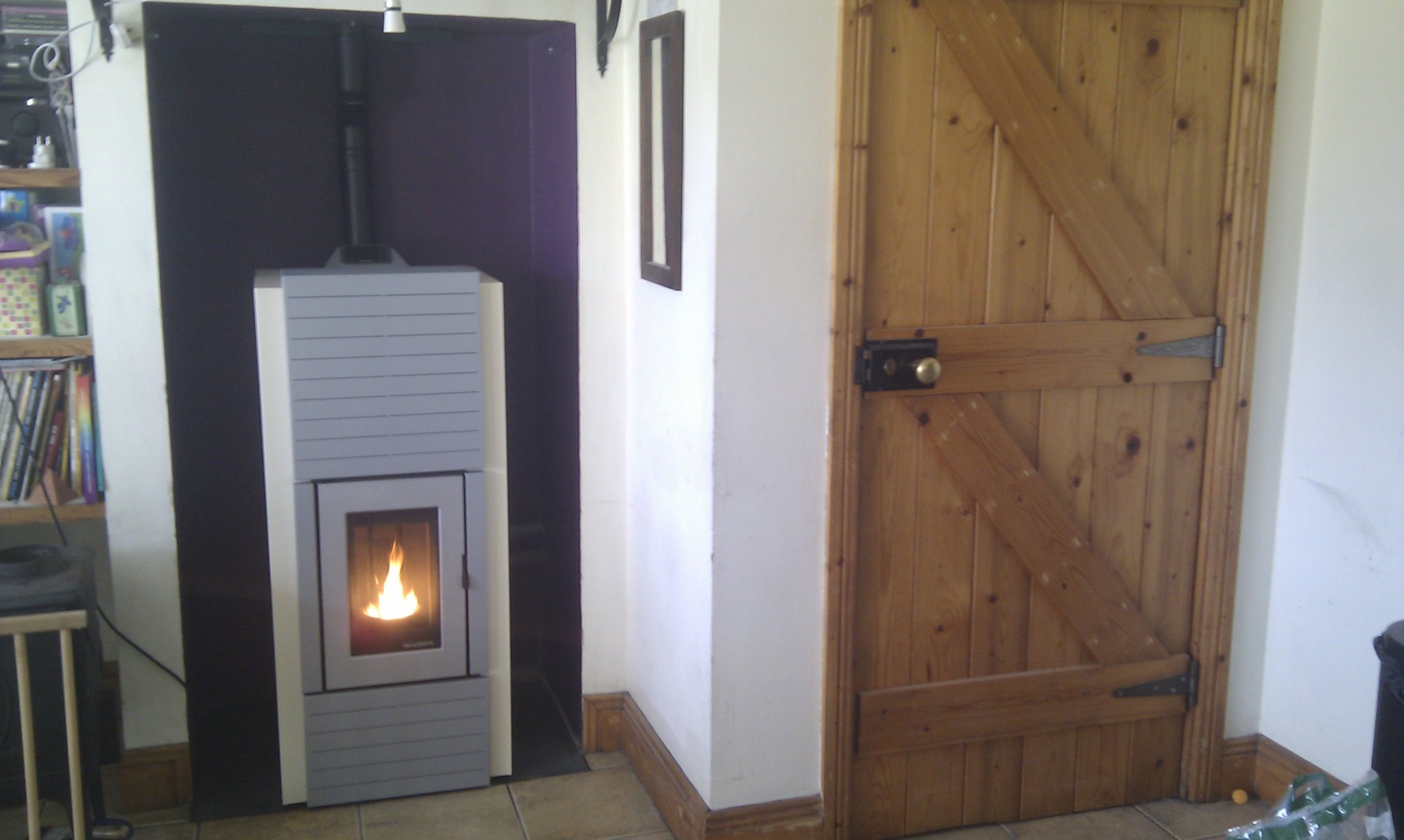 Pellet stove fitted in a room beside a timber door