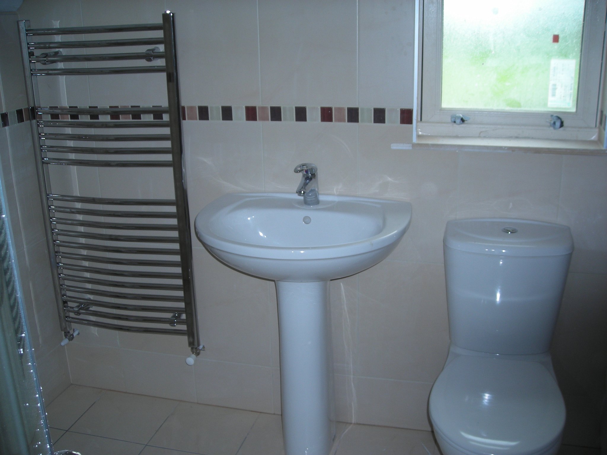 Pedestal basin, toilet and chrome heated towel rail