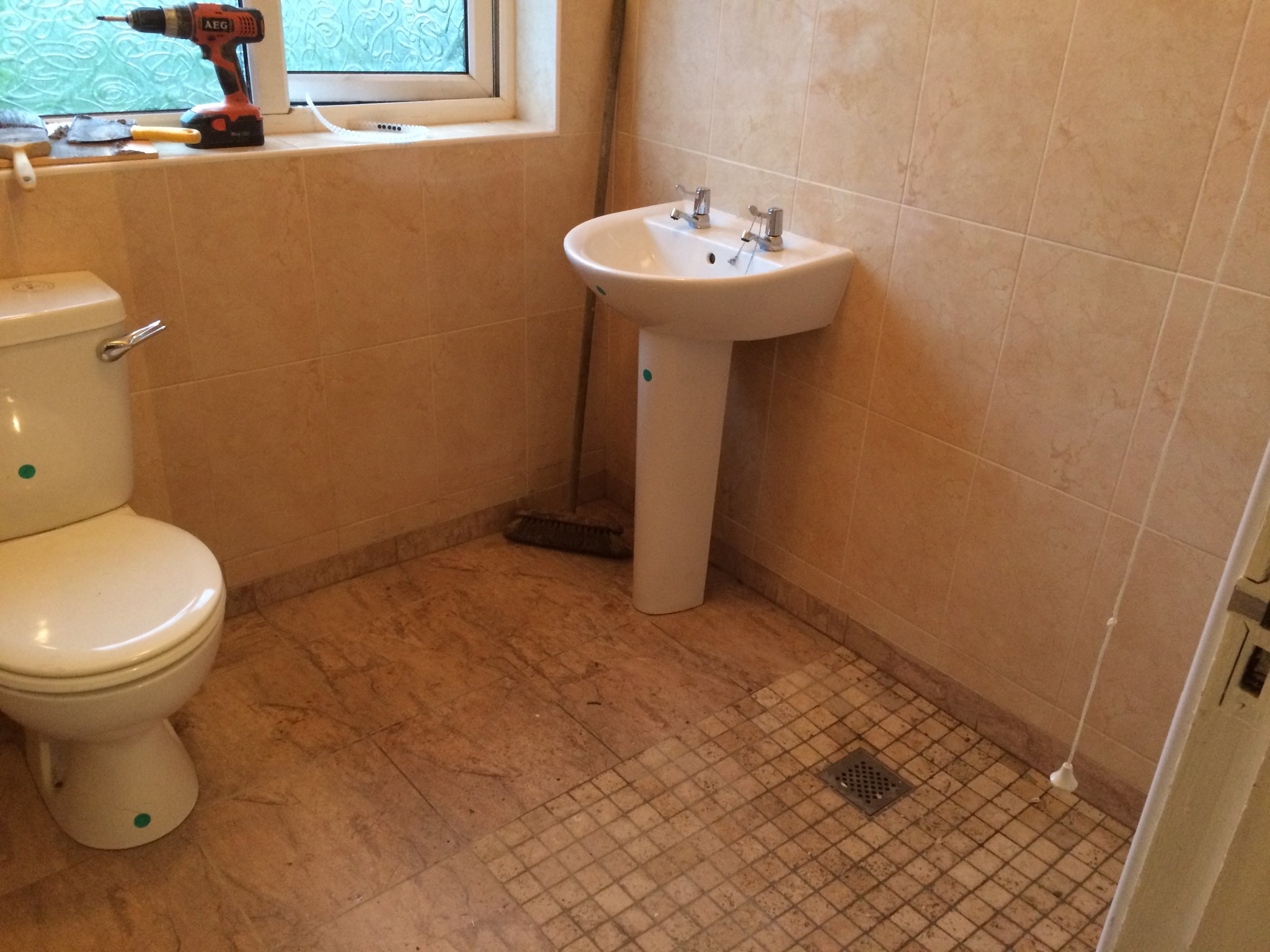 Bathroom with a mosaic floor and pedestal basin